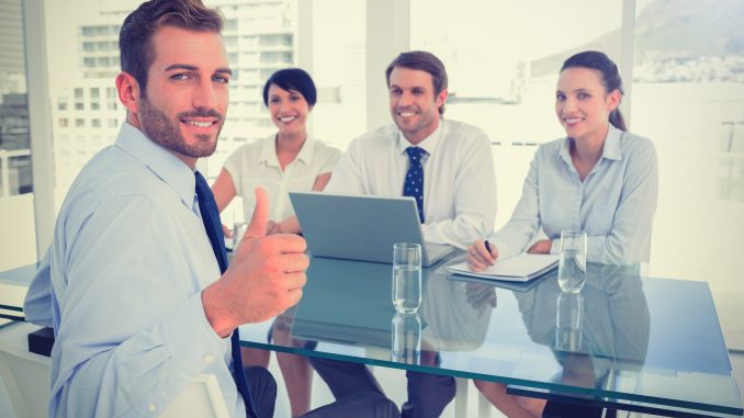 Executive gesturing thumbs up with recruiters during interview